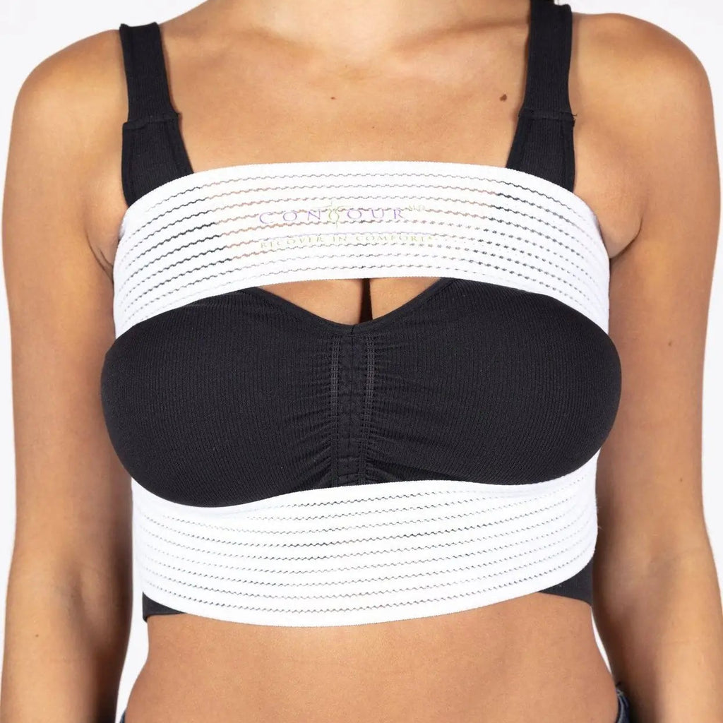 A woman wearing a black and white strappy crop top with wide horizontal white bands and a black sweetheart neckline, paired with dark blue jeans.