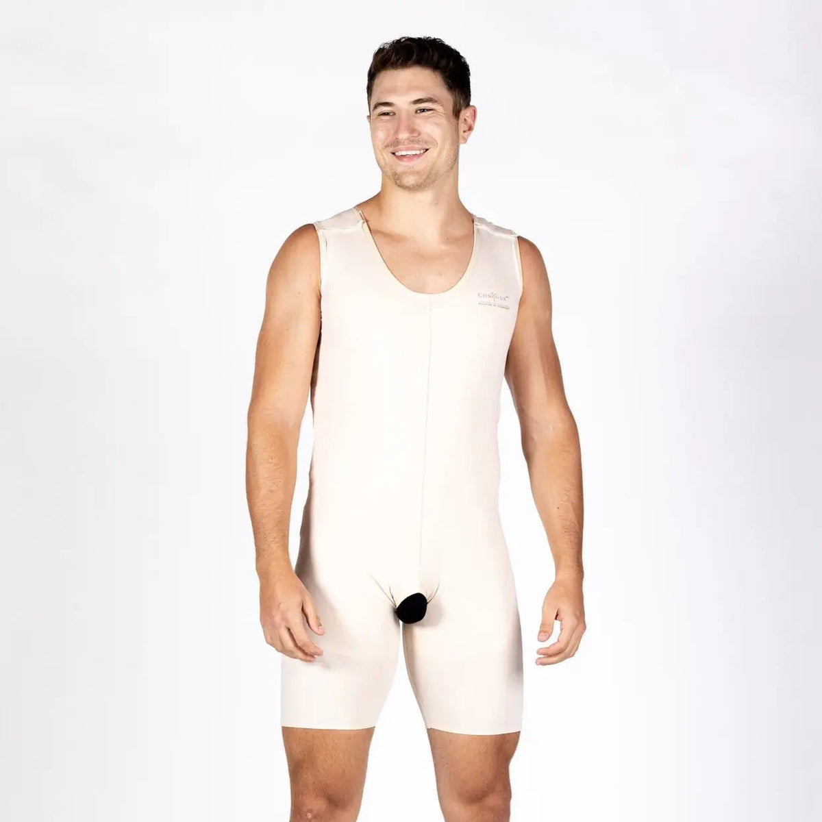A man modeling a beige compression brief or shapewear suit against a plain white studio background.