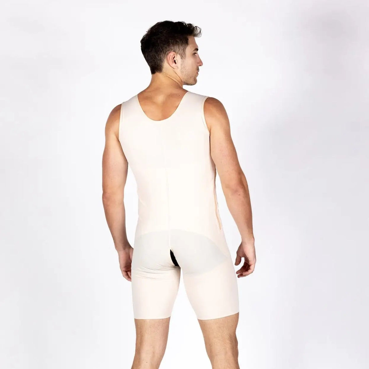 A man shown from the back wearing a light beige compression vest and matching compression shorts against a plain white studio background.