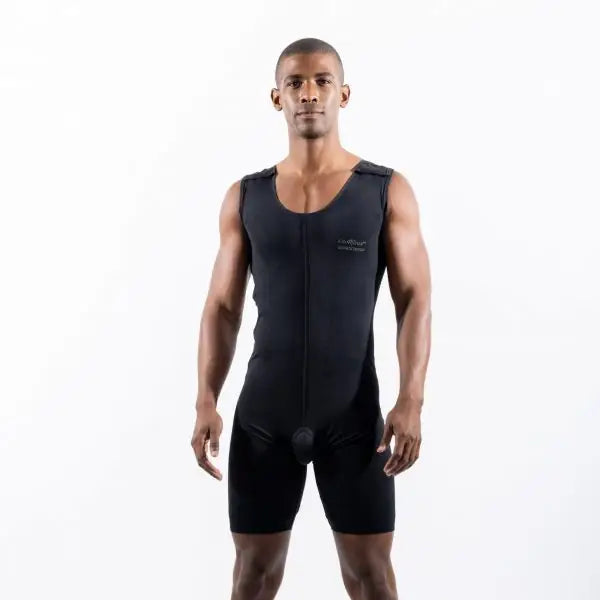 A man modeling a black athletic compression suit with integrated shorts and a front zipper, standing against a plain white studio background.