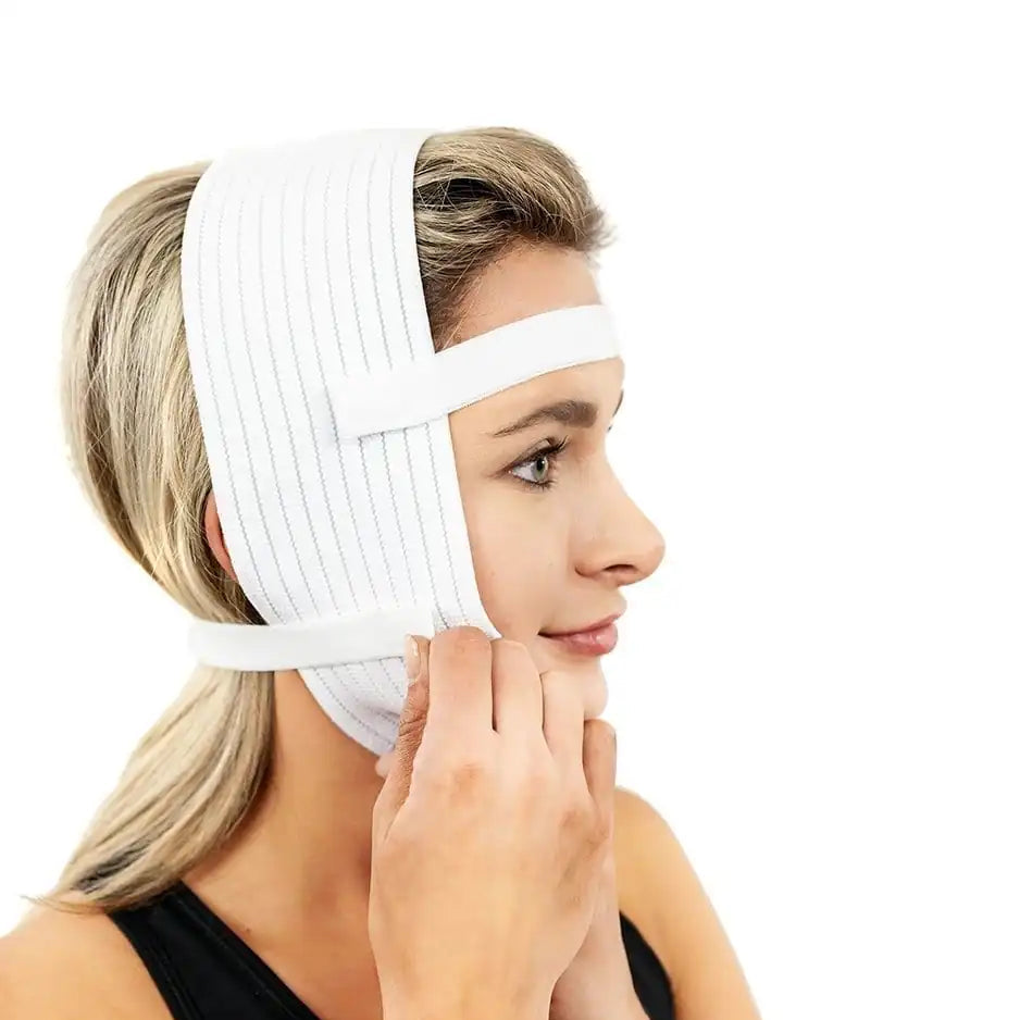 A woman wearing a white compression headband and adjusting a lower facial support band, shown in profile against a plain white background.