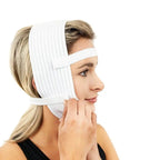 A woman wearing a white compression headband and adjusting a lower facial support band, shown in profile against a plain white background.